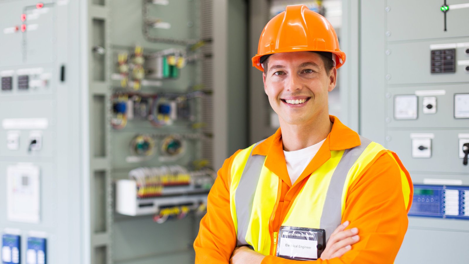 happy electrical engineer standing in control room
